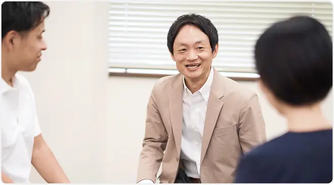 相談中に笑顔を見せる男性と二人の参加者