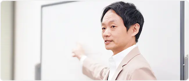 ホワイトボードに向かってプレゼンをする男性