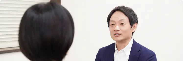 カウンセリングを受ける女性と、対面で話すカウンセラーの男性