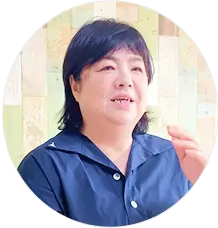 紺色のシャツを着た笑顔の介護スタッフの女性