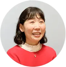 赤いセーターを着た笑顔の介護スタッフの女性